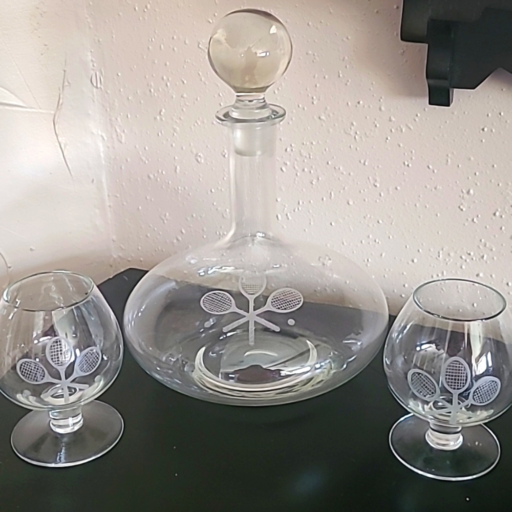 Tennis decanter and two Brandy sniffers all etched on beautiful glass.